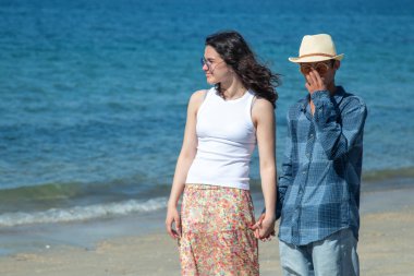 Yürüyen el ele sahilde genç Çift