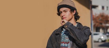 Kentli genç adam sokakta ciddi düşünüyor.