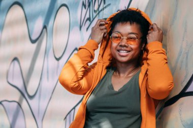 Duvarda grafitisi olan siyah bir kadın.