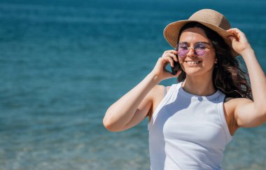 girl smiling happy using smartphone at the beach clipart
