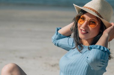 Kumsalda oturan rahat genç bayan.