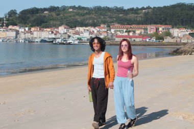 Kumsalda rahatça yürüyen bir çift.