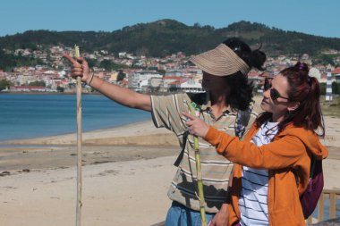 Bir çift gezgin turist manzaranın tadını çıkarıyor ve bir yön gösteriyor.