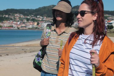 Sırt çantalı turist çift plaj manzarasının tadını çıkarıyor.