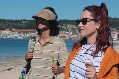 Sırt çantalı turist çift plaj manzarasının tadını çıkarıyor.