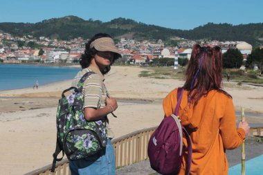 Sırt çantalı turist çift plaj manzarasının tadını çıkarıyor.