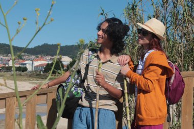 Sırt çantalı iki turist doğada eğleniyor.