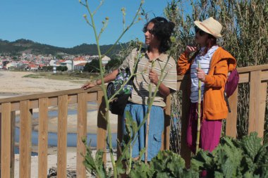 Sırt çantalı iki turist doğada eğleniyor.