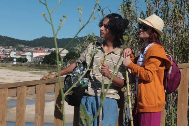 Sırt çantalı iki turist doğada eğleniyor.