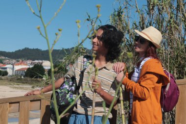 Sırt çantalı iki turist doğada eğleniyor.