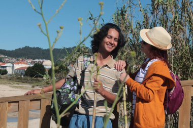 Sırt çantalı iki turist doğada eğleniyor.