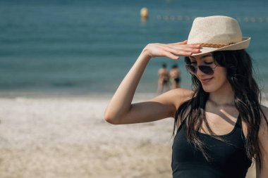 Plajda şapka ve güneş gözlüklü bir turist portresi.