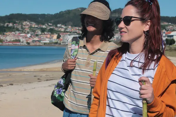 Sırt çantalı turist çift plaj manzarasının tadını çıkarıyor.