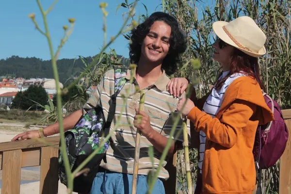 Sırt çantalı iki turist doğada eğleniyor.