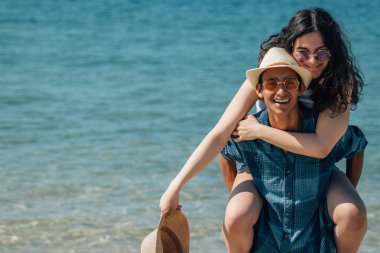 Mutlu ve sevgi dolu genç bir çiftin portresi. Yazın kumsalda eğleniyor.