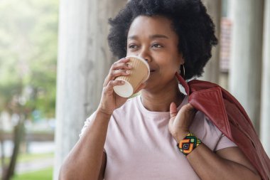 Sokakta kahve içen şehirli kadın.