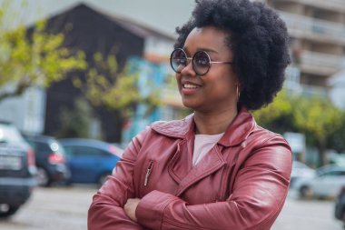 Sokakta kollarını kavuşturmuş şehirli bir kadın.