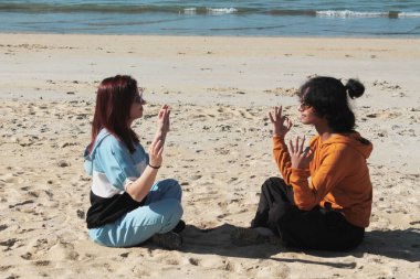 Kumsalda rahat bir çift, zen egzersizleri yapıyor.