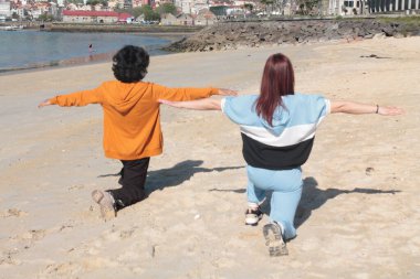 Çift sahilde jimnastik yapıyor.