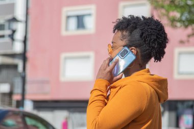 Sokakta telefonu olan siyahi bir kadın.