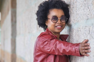 Duvarda eski model gözlüklü, eski model afro kadın resmi var.