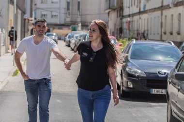 Sokakta el ele tutuşan genç bir çift.