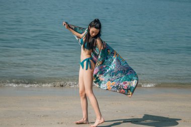 İnsanlar, yaz ve mayo konsepti - bikinili bir kadın ve plajda pareo.