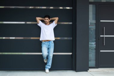 Duvara yaslanan genç şehirli adam