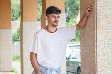 modern genç adam sokakta duvarda poz veriyor.