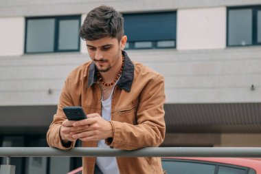 Sokakta cep telefonuna bakan sıradan bir genç.