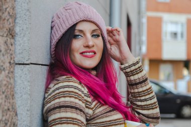 Kışın elinde bir fincan kahve tutan genç bir kadın