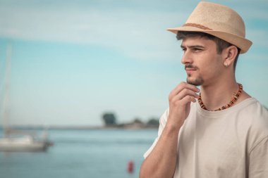 Denize bakan düşünceli genç adam.