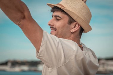 Özgür adam kumsalda dinleniyor. Kolları havada. Temiz hava soluyor.