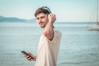 Sahildeki genç adam kulaklık takıyor....