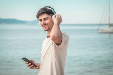 Sahildeki genç adam kulaklık takıyor....