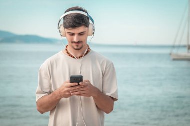 Sahildeki genç adam kulaklık takıyor....