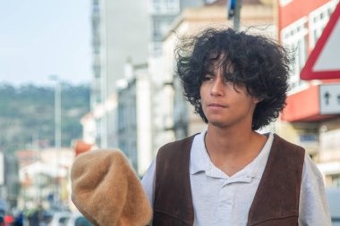 Sokakta şapkalı genç Latin bir adam.