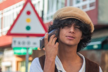 Sokakta cep telefonuyla sürpriz bir hareket yapan genç adam.