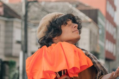 Genç adam yağmurun yağışını izlerken sokakta bir şemsiye açıyor.