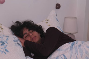 Delikanlı evinde huzur içinde uyuyor.