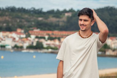 Kumsalda yürüyen çekici genç adam.