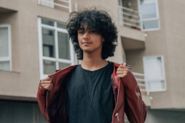 Sokakta deri ceketli genç bir adamın portresi.