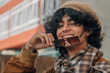 Geçmişten kalma güneş gözlüğü takan sıradan bir genç.