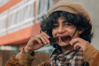 Geçmişten kalma güneş gözlüğü takan sıradan bir genç.