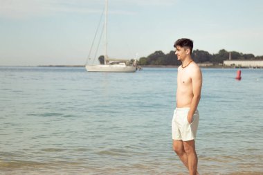 Genç adam sahilde yürüyordu.