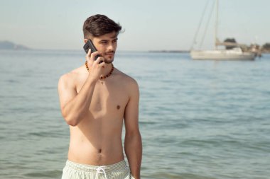 Sahilde telefonda konuşan genç adam