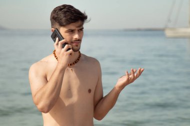 Sahilde telefonda konuşan genç adam