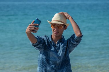 Telefonu olan genç adam selfie mi çekiyor yoksa canlı video mu?