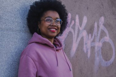 Duvarda grafitisi olan siyah bir kadın.