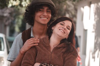 Düğün çifti sokakta sarılıyor.